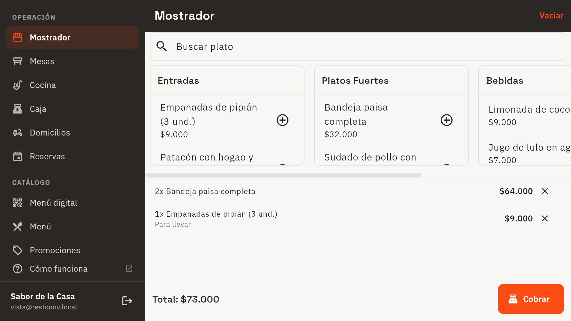 Pantalla de mostrador de Restonov con un pedido en curso: dos bandejas paisas y unas empanadas para llevar, total de 73.000 pesos y el botón para cobrar.